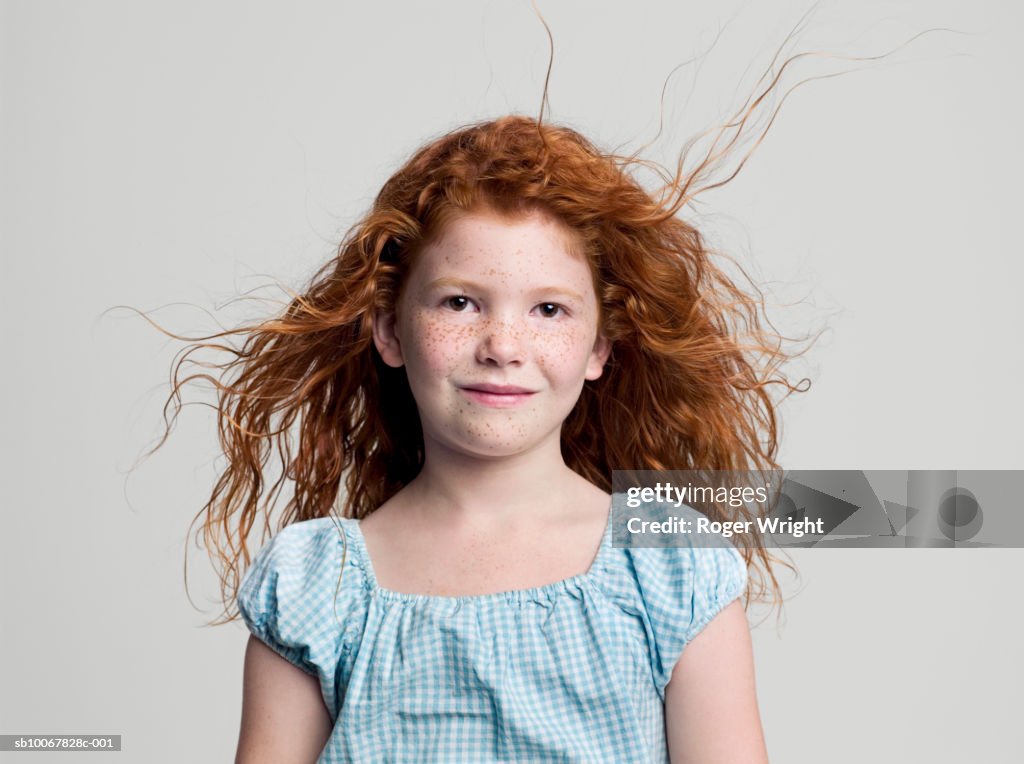 Studio portrait of girl (8-9 years) with red hair