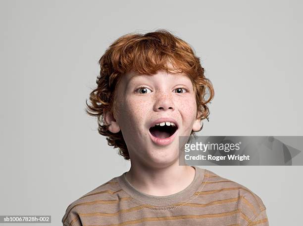 boy (8-9 years) with open mouth, portrait, studio shot - expresiones de la cara fotografías e imágenes de stock