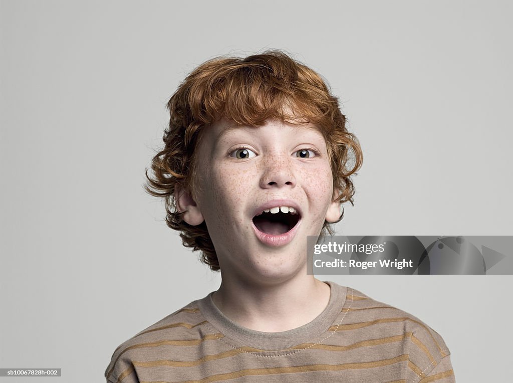 Boy (8-9 years) with open mouth, portrait, studio shot