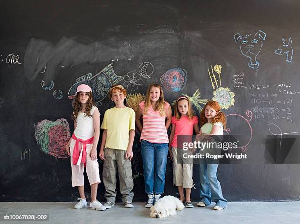 group of children (7-9 years) standing in front of chalkboard, portrait - 6 7 years stock-fotos und bilder