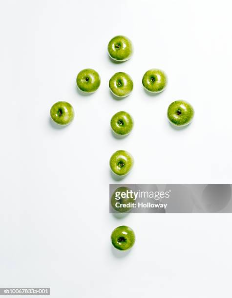 arrow made from green apples on white background - apple arrow stock-fotos und bilder