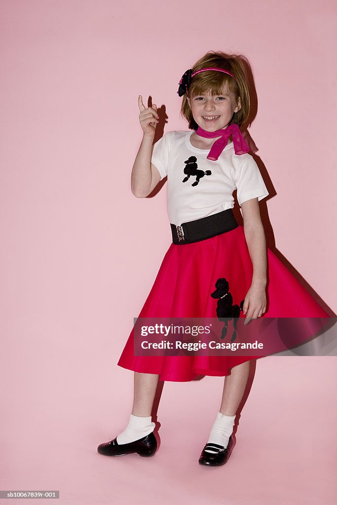 Portrait of young girl (6-7) on pink background