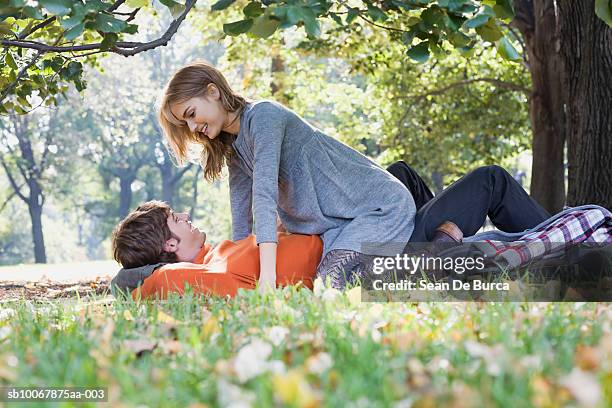 young couple in park, smiling - couple central park stockfoto's en -beelden