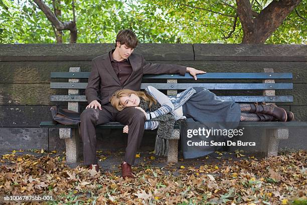 woman lying on man's lap at park - couple central park stockfoto's en -beelden