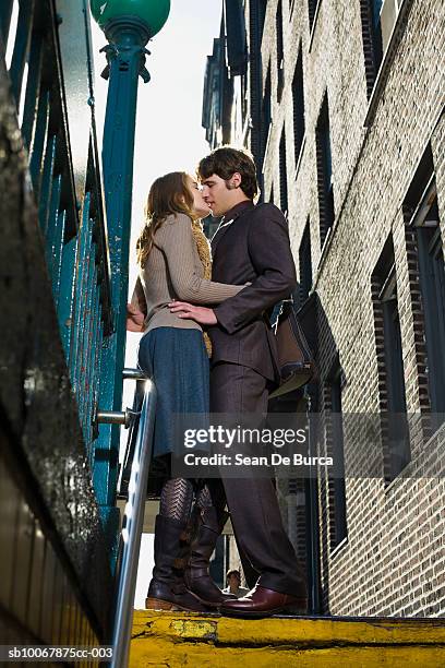 young couple kissing, low angle view - couple central park stock pictures, royalty-free photos & images