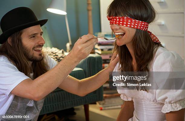 man feeding blindfolded woman, smiling - blind fold stock pictures, royalty-free photos & images