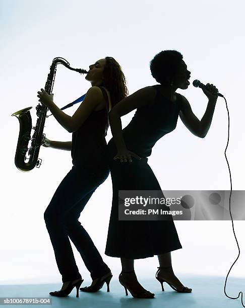 silhouette of female singer and saxophone player - 木管楽器 ストックフォトと画像