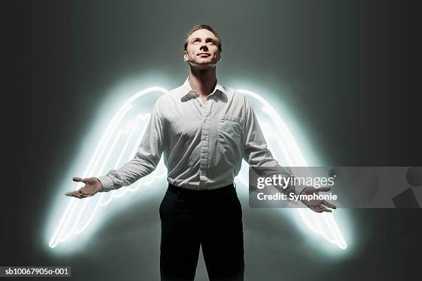 man with glowing angel wings (digital composite) - man angel wings stock pictures, royalty-free photos & images