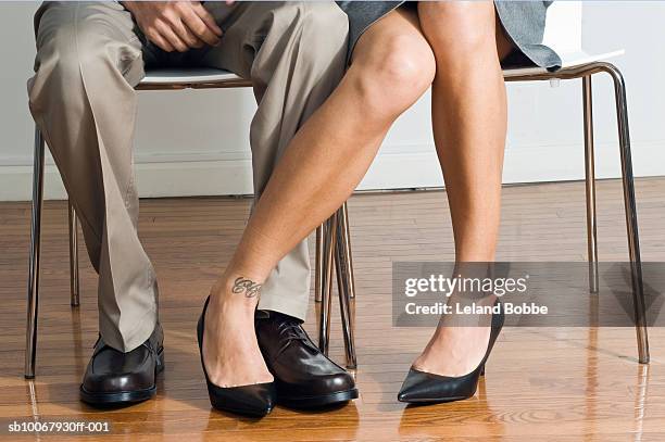 businessman and woman playing footsie, low section, close-up - playing footsie stock-fotos und bilder