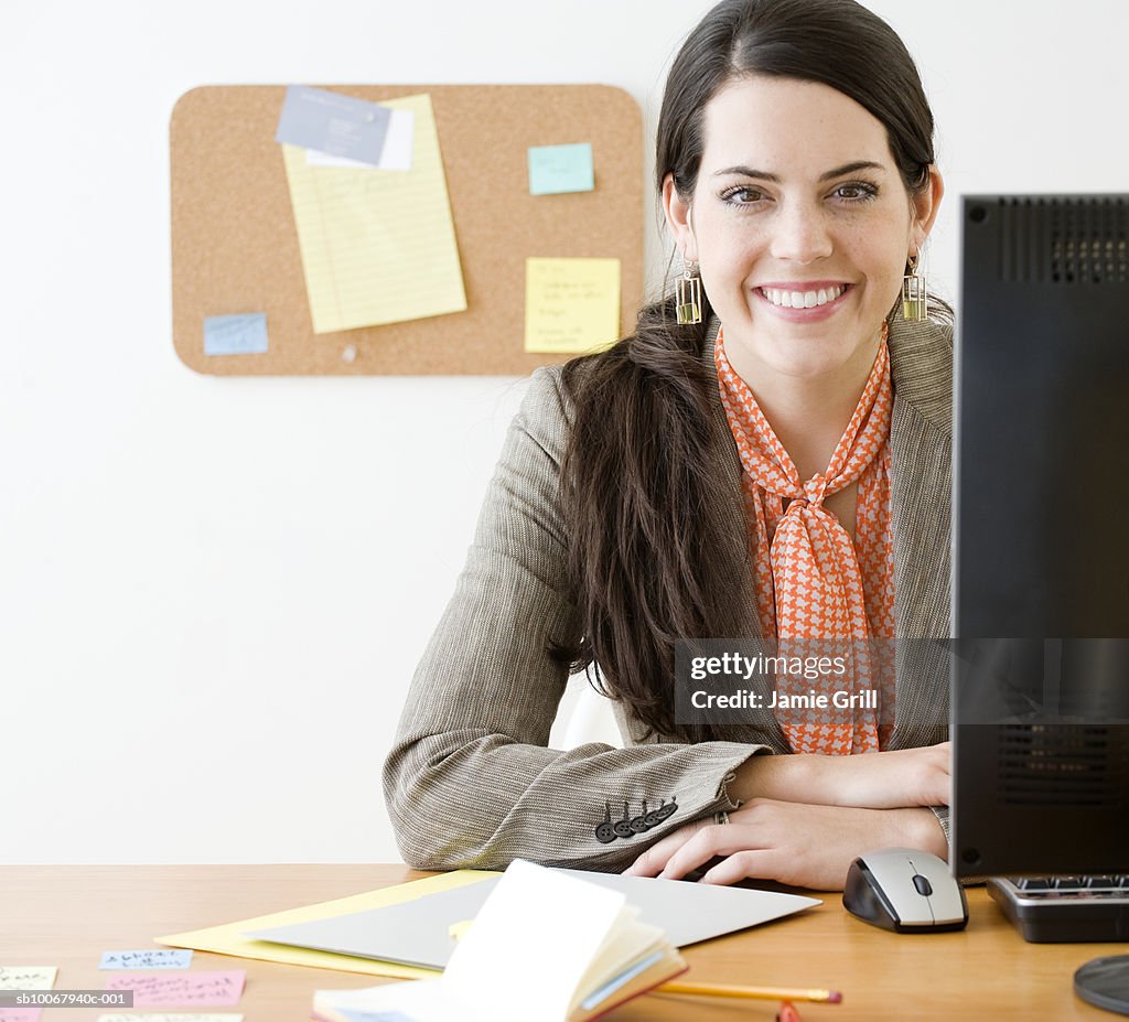 Portrait of young woman at office desk