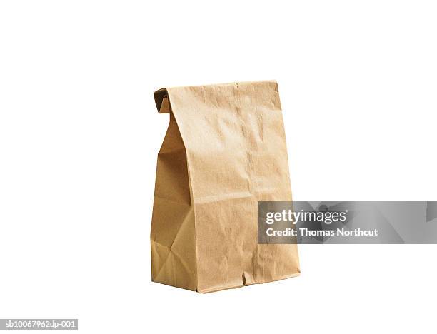 brown lunch bag on white background - paper bag stock-fotos und bilder