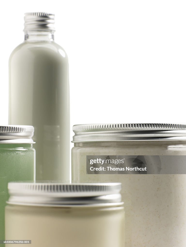 Jars of skin care products on white background