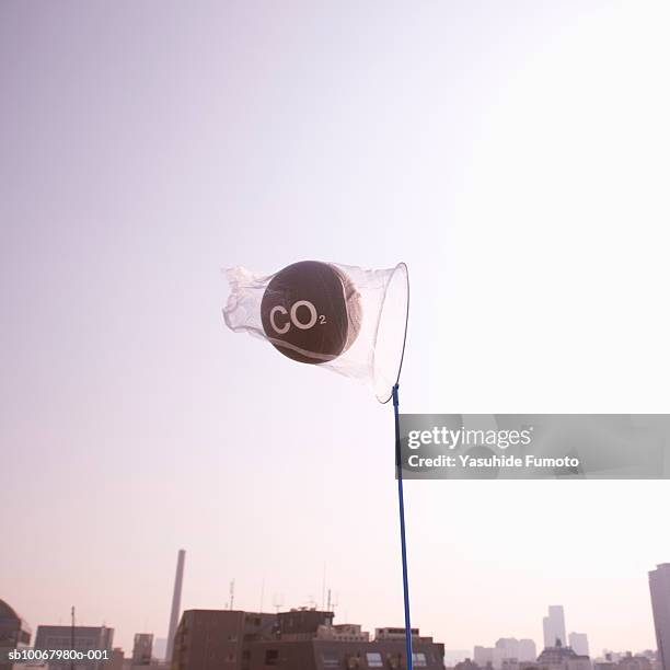 net catching carbon dioxide molecule over city at dusk - dióxido de carbono fotografías e imágenes de stock