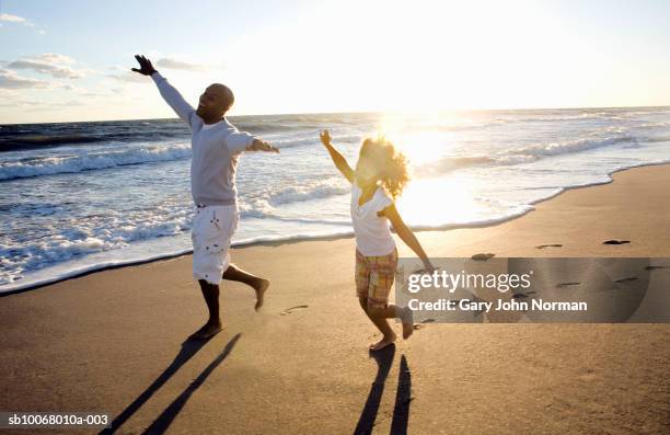 father and daughter (6-7) playing at beach, smiling - familia en la playa fotografías e imágenes de stock