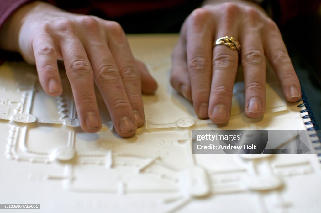 Person reading braille with fingers, close-up