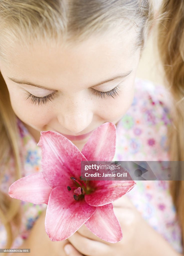 Girl (6-7) smelling Tiger Lily, close-up