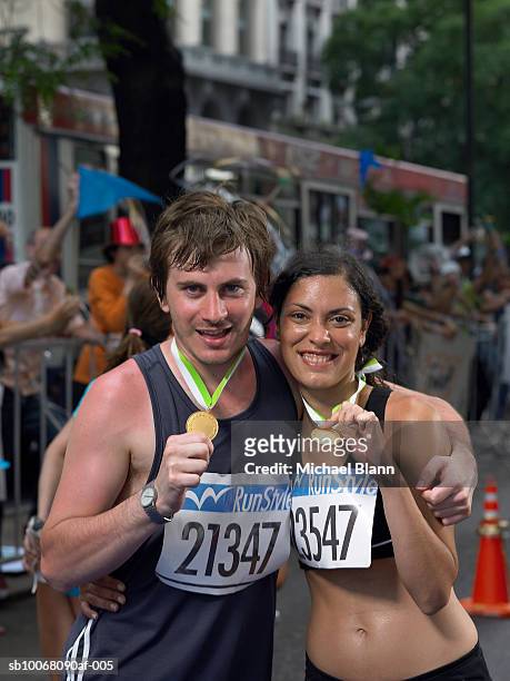 two marathon runners showing off medals, portrait - marathon medal stock pictures, royalty-free photos & images