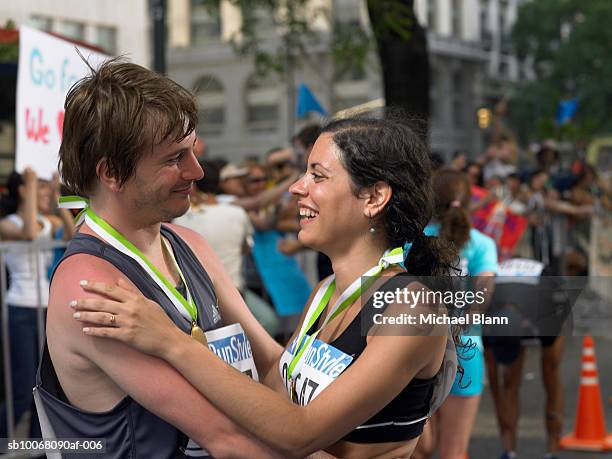 two marathon runners embracing and smiling - marathon medal stock pictures, royalty-free photos & images