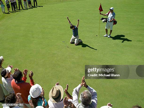 male golfer cheering on course, spectators applauding, high angle view - golf excitement stock pictures, royalty-free photos & images