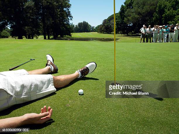 golfer lying on course (low section), people in background - unconscious person stock pictures, royalty-free photos & images