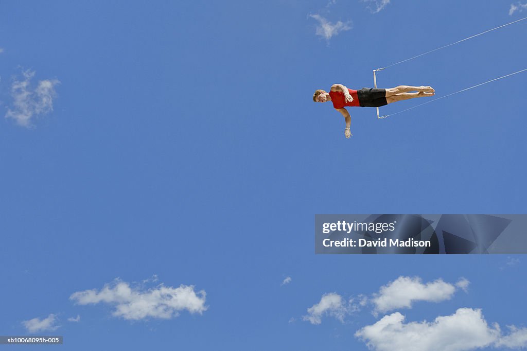 Male trapeze artist, low angle view