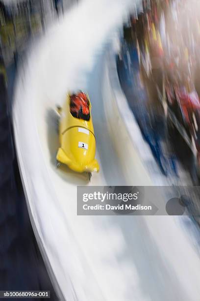 four-man bobsled on track, blurred motion - bobrennschlitten stock-fotos und bilder