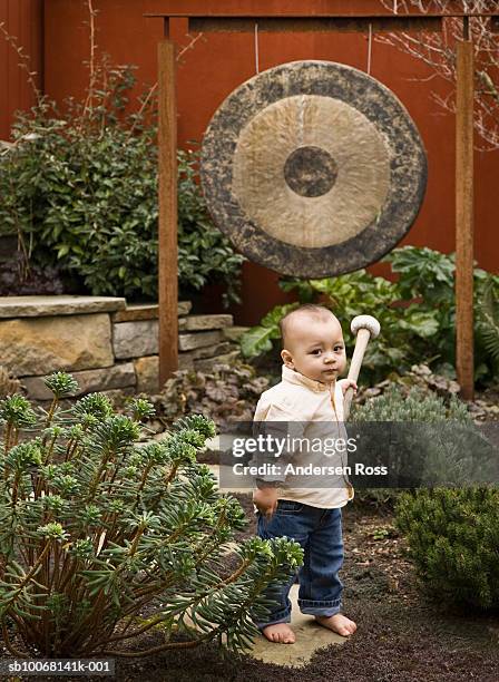 baby boy (15-18 months) holding gong mallet, portrait - percussion mallet stock-fotos und bilder