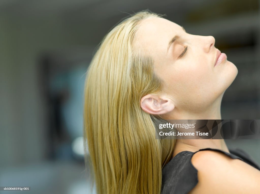 Woman tilting head back, side view, close up