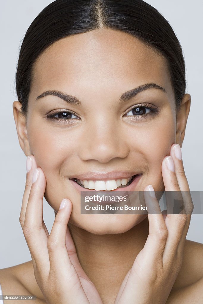 Studio portrait of teenage girl (16-17) smiling