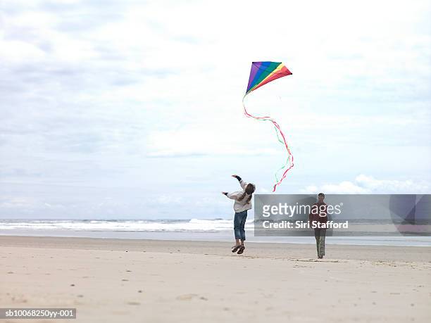 pai com filha (8-9) voar pipa na praia - cannon beach imagens e fotografias de stock
