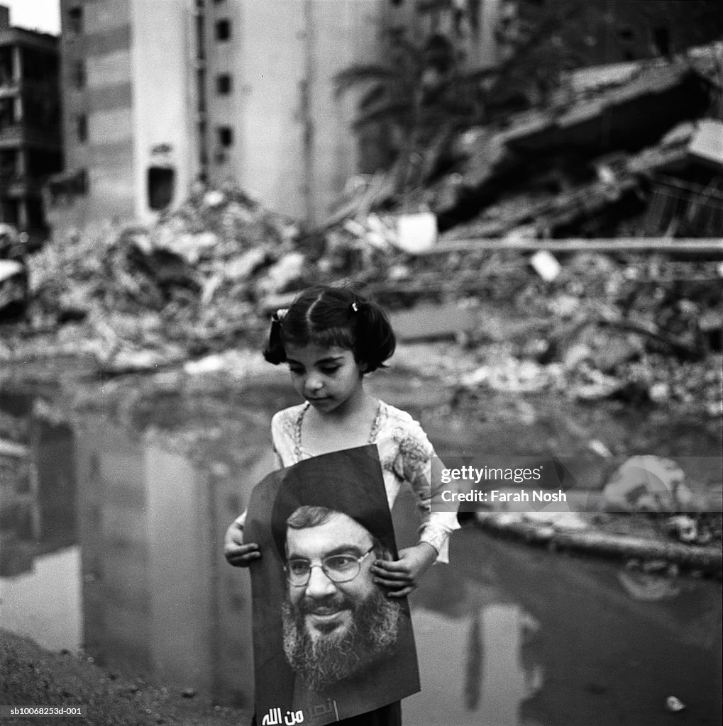 Lebanon, Beirut, girl (6-7) carrying poster of Hezbollah leader Hassan Nasrallah, outdoors
