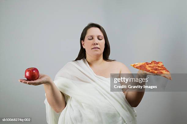 overweight women holding apple and pizza, eyes closed, close-up - funny fat women 個照片及圖片檔