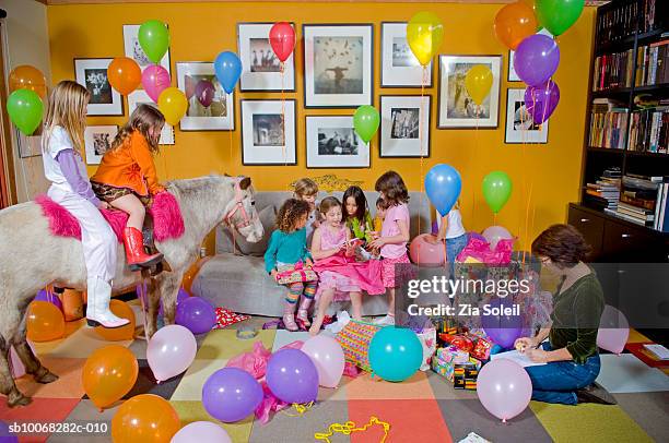 children (4-7) opening gifts at birthday party - birthday present stock pictures, royalty-free photos & images