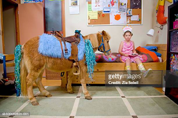 girl (6-7) with pony in bedroom - pony stock pictures, royalty-free photos & images