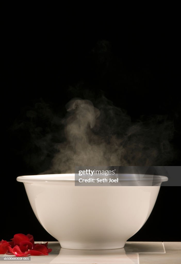 Steam rising from white basin of hot water