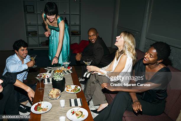 group of friends around table at cocktail party - black people cocktail party stockfoto's en -beelden