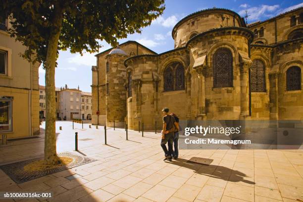 france, rhone-alpes, rhone valley, drome, valence, young couple passing cathedral of st. apollinaire - rhone stock pictures, royalty-free photos & images