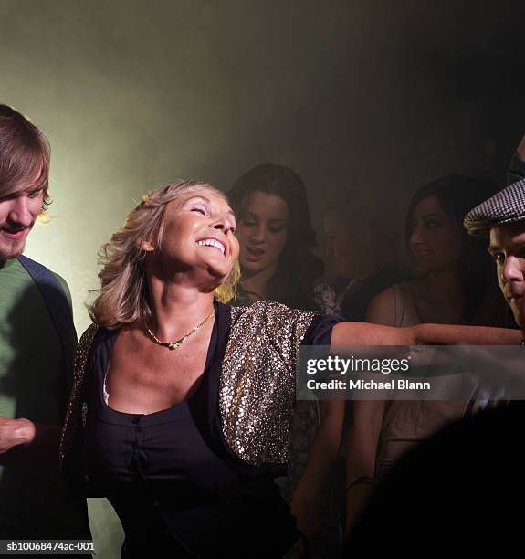 senior woman dancing with friends in night club - senior women dancing stock pictures, royalty-free photos & images