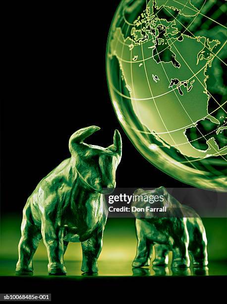 bear and bull models with globe in background - bull bear stock pictures, royalty-free photos & images