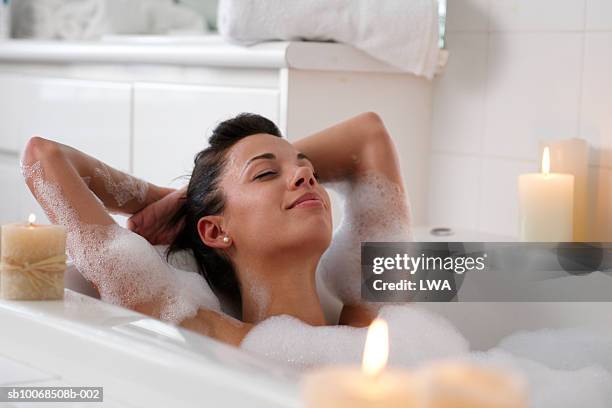 young woman in bubble bath, smiling - bathtime foto e immagini stock