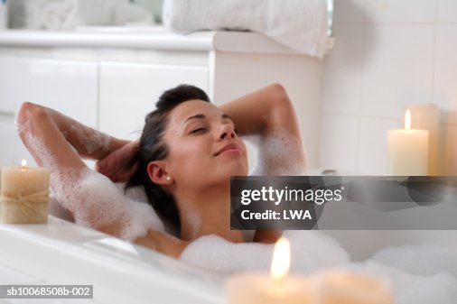 Young woman in bubble bath, smiling Young woman in bubble bath, smiling