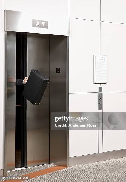 businessman wedged between elevator doors - elevator trapped stock pictures, royalty-free photos & images