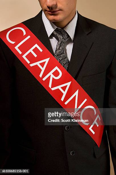 business man wearing sash reading 'clearance', mid section - sash fotografías e imágenes de stock