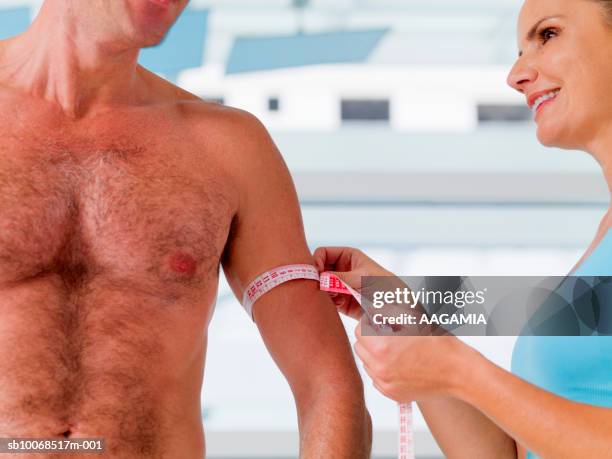 woman measuring man's biceps, close-up - female hairy chest photos et images de collection