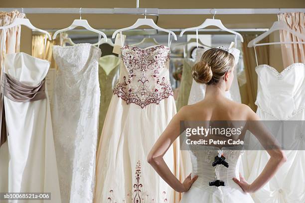 bride looking at rack of dresses - sposa foto e immagini stock