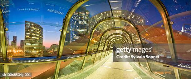 france, paris, la defense, covered elevated walkway at dusk - paso elevado fotografías e imágenes de stock