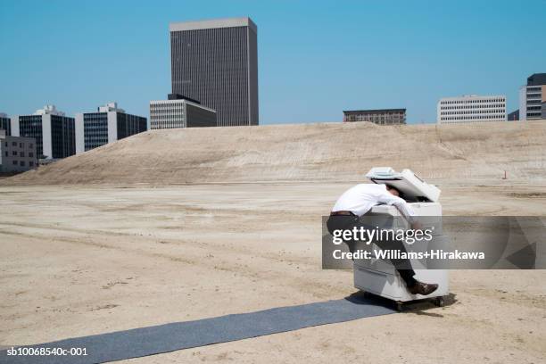 man with head in copy machine on construction site, side view - stressed funny stock pictures, royalty-free photos & images