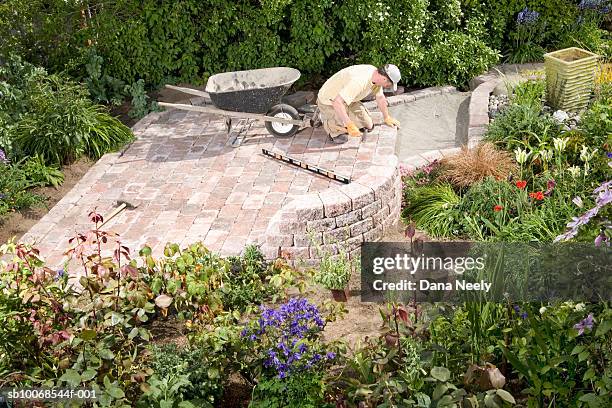 man lying paving stones in garden, elevated view - paralelepípedo - fotografias e filmes do acervo