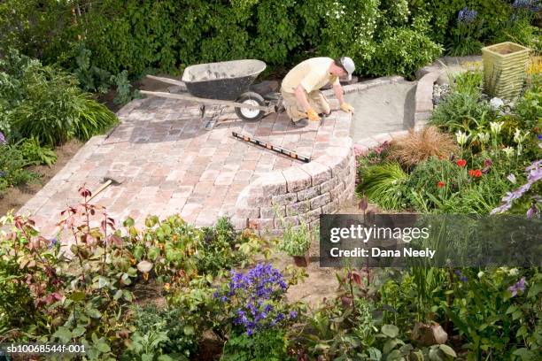 man lying paving stones in garden, elevated view - 鋪路石板 個照片及圖片檔