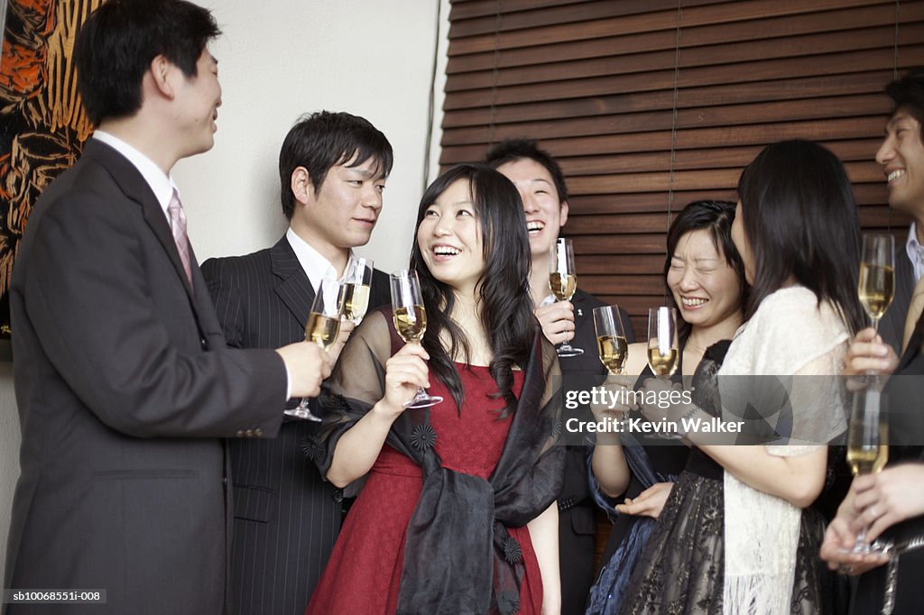 Group of friends holding champagne flute, smiling
